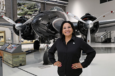 Anna Hawley standing in front of plane at Lone Star Flight Museum